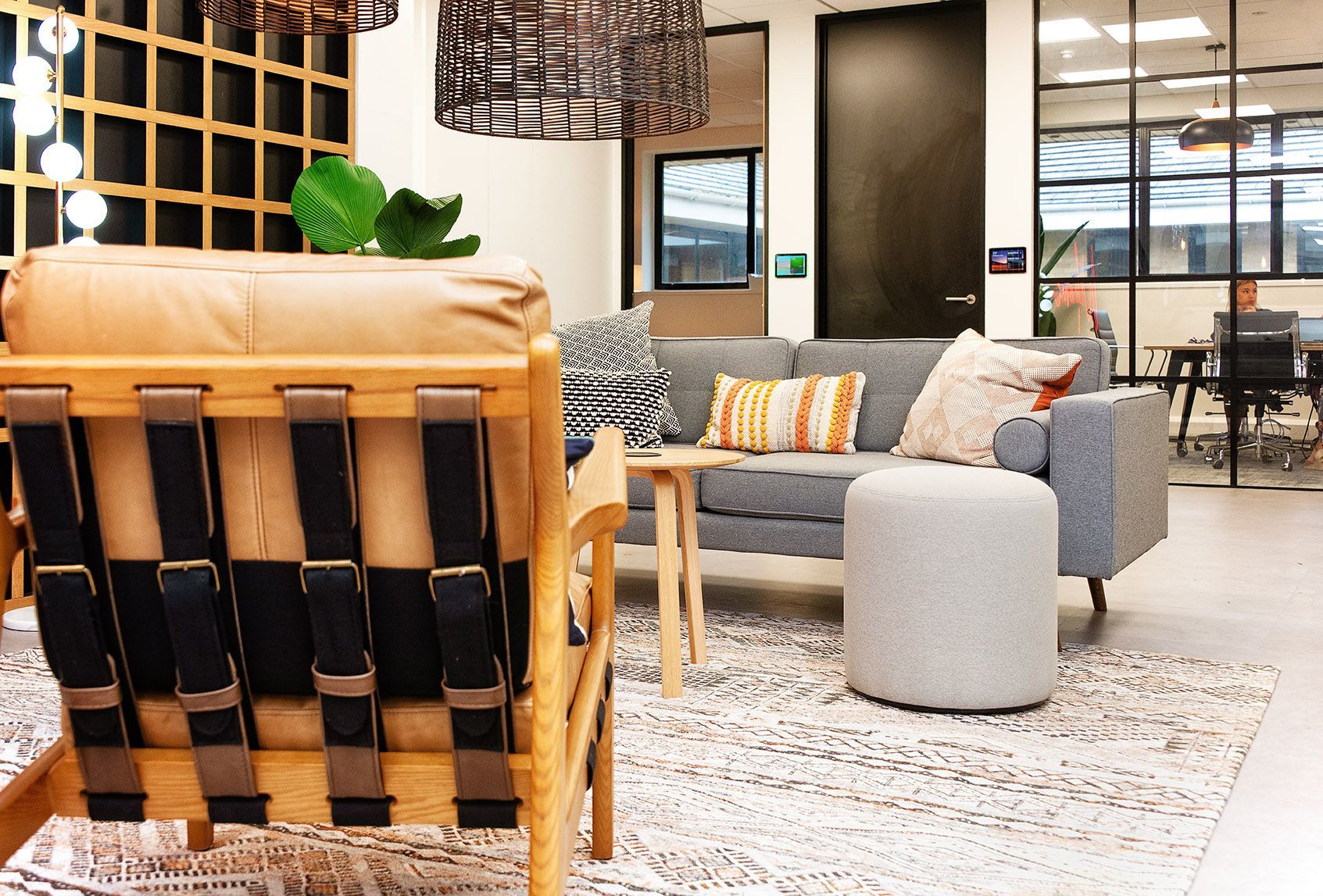A living room with a couch , chairs , ottoman and table.