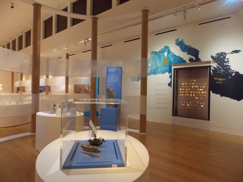 A museum with a map on the wall behind a glass case