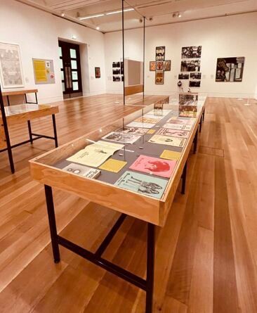 A long wooden table in a room with a lot of pictures on it