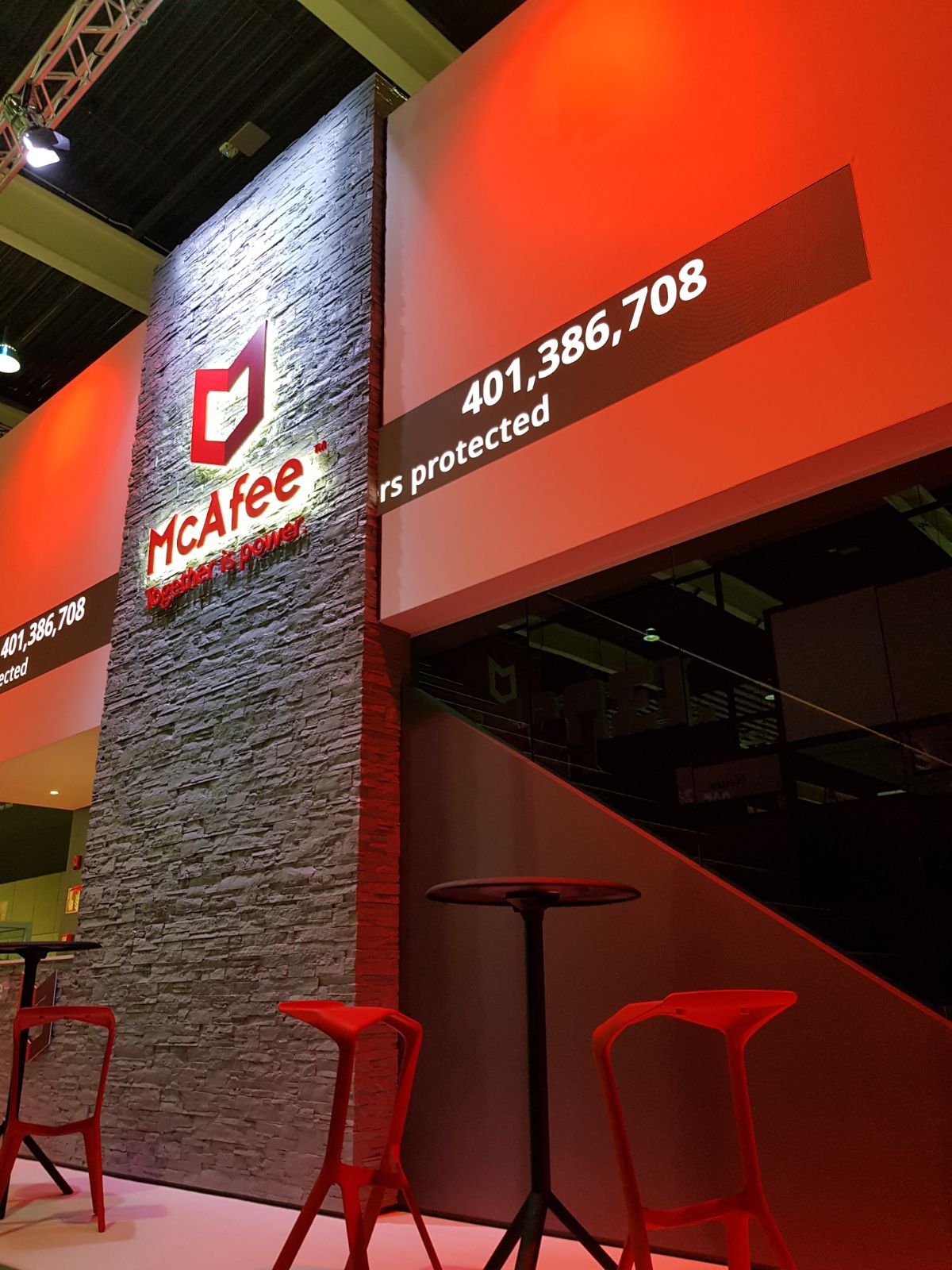 A mcafee booth with red chairs and tables