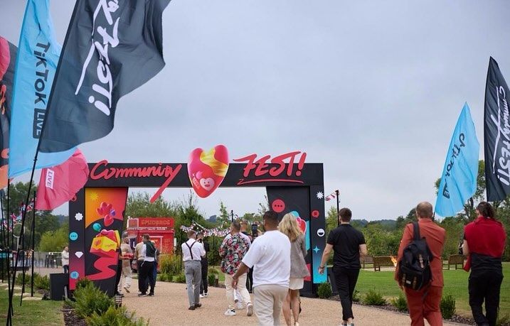 A group of people are walking through an entrance to a festival.