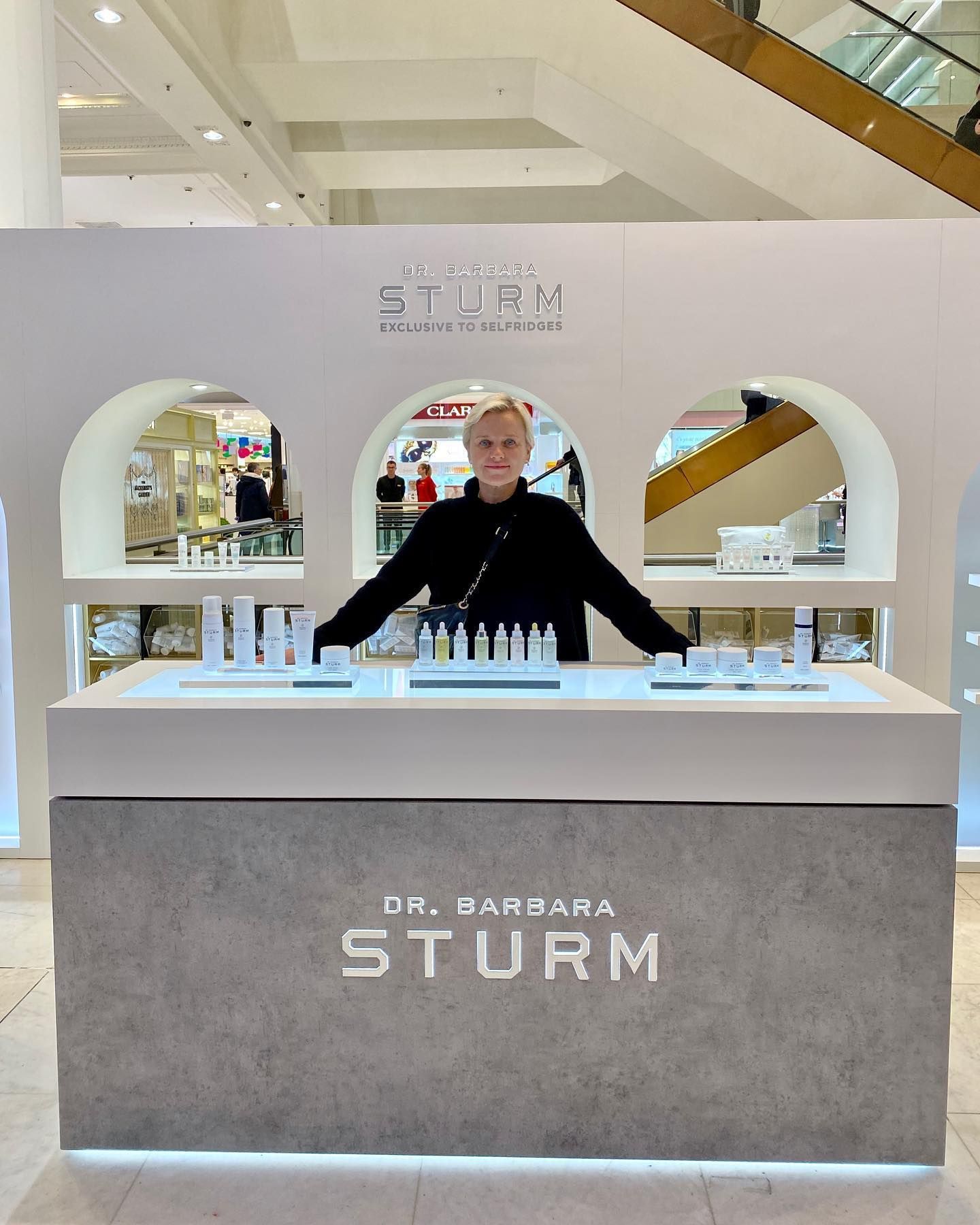 A woman is standing in front of a counter that says sturm
