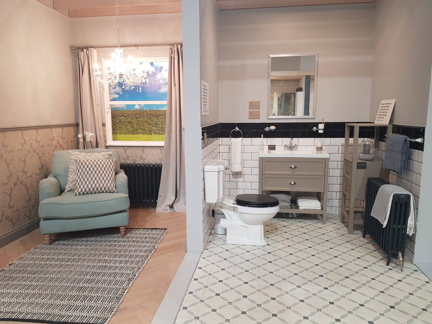 A bathroom with a toilet , sink , chair and window.