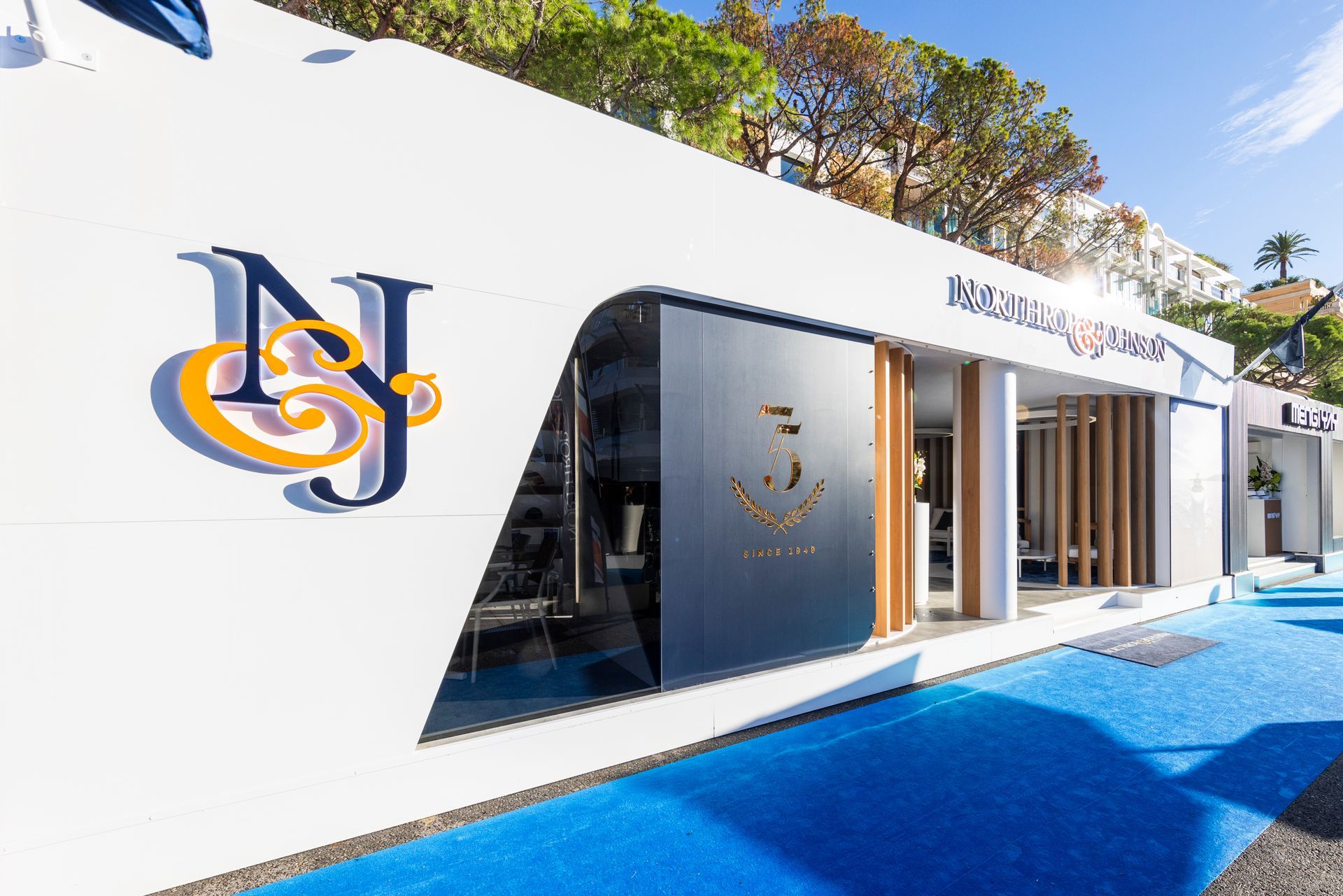 A white building with a blue carpet in front of it.