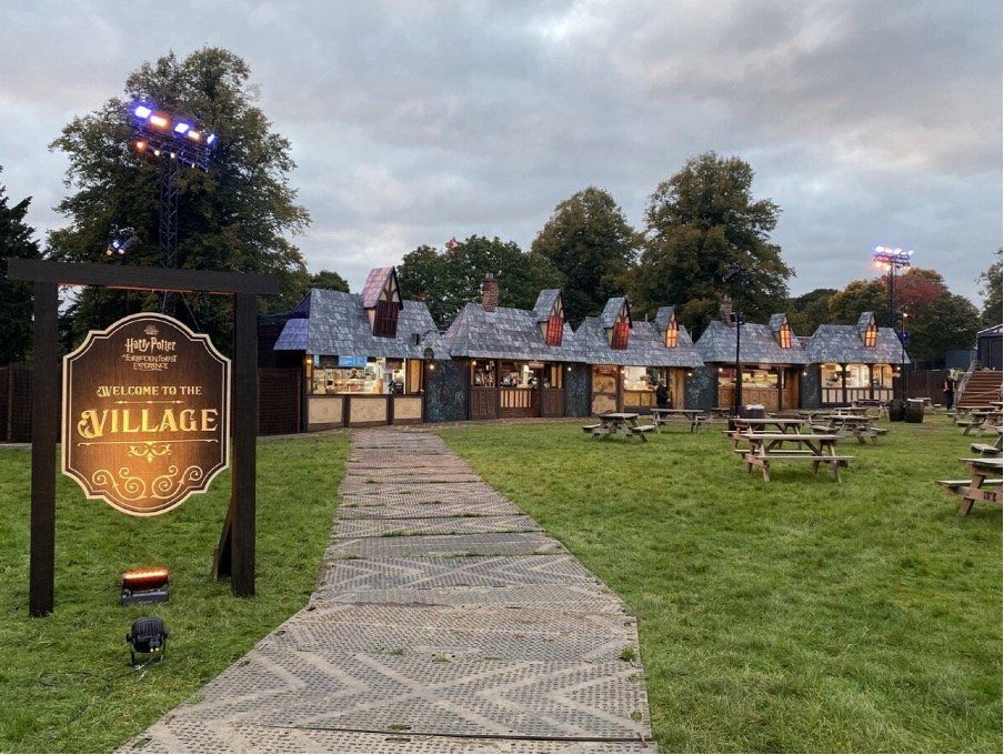 A sign that says village is in front of a row of houses