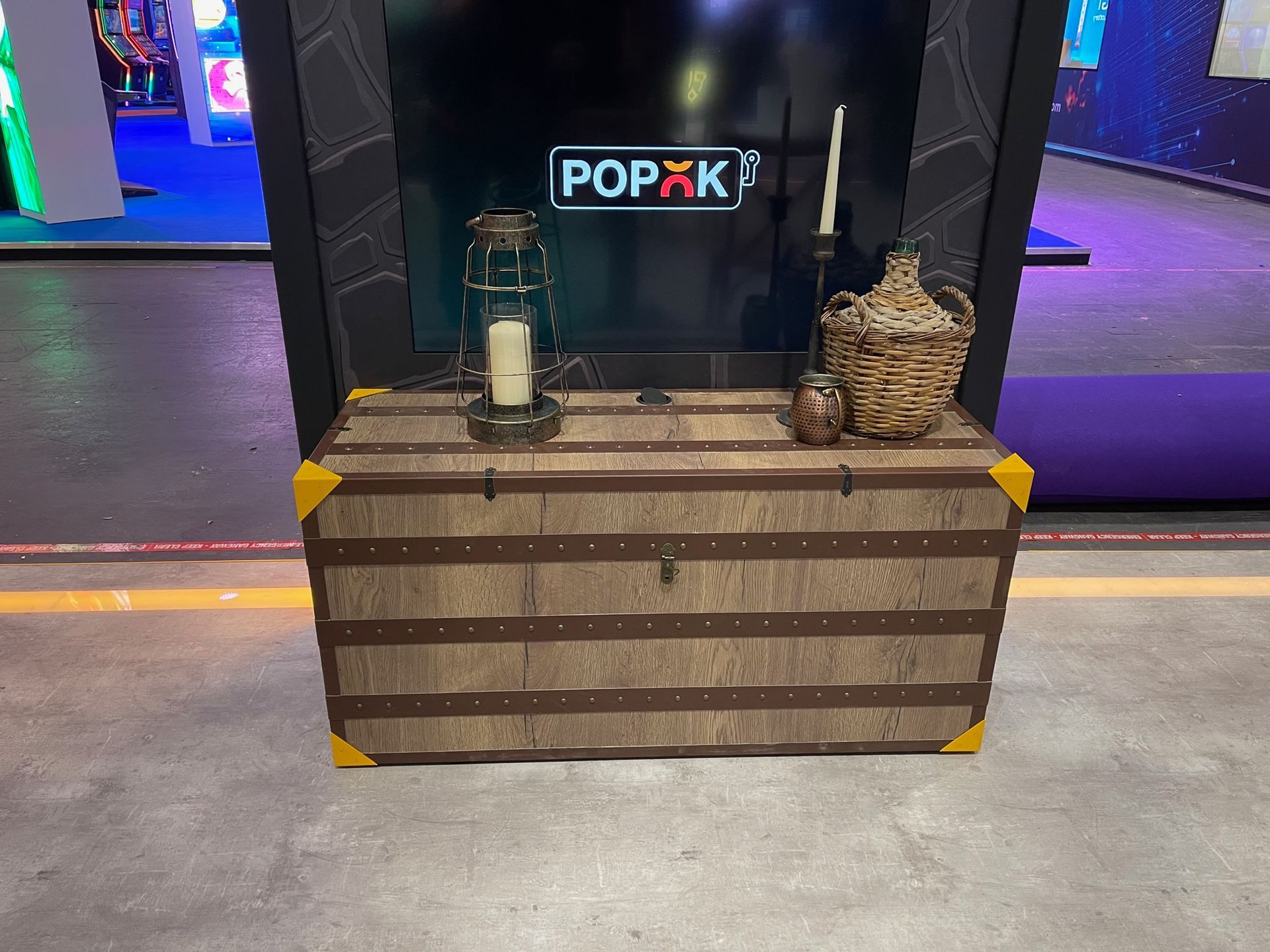 A wooden trunk is sitting in front of a screen that says popxk