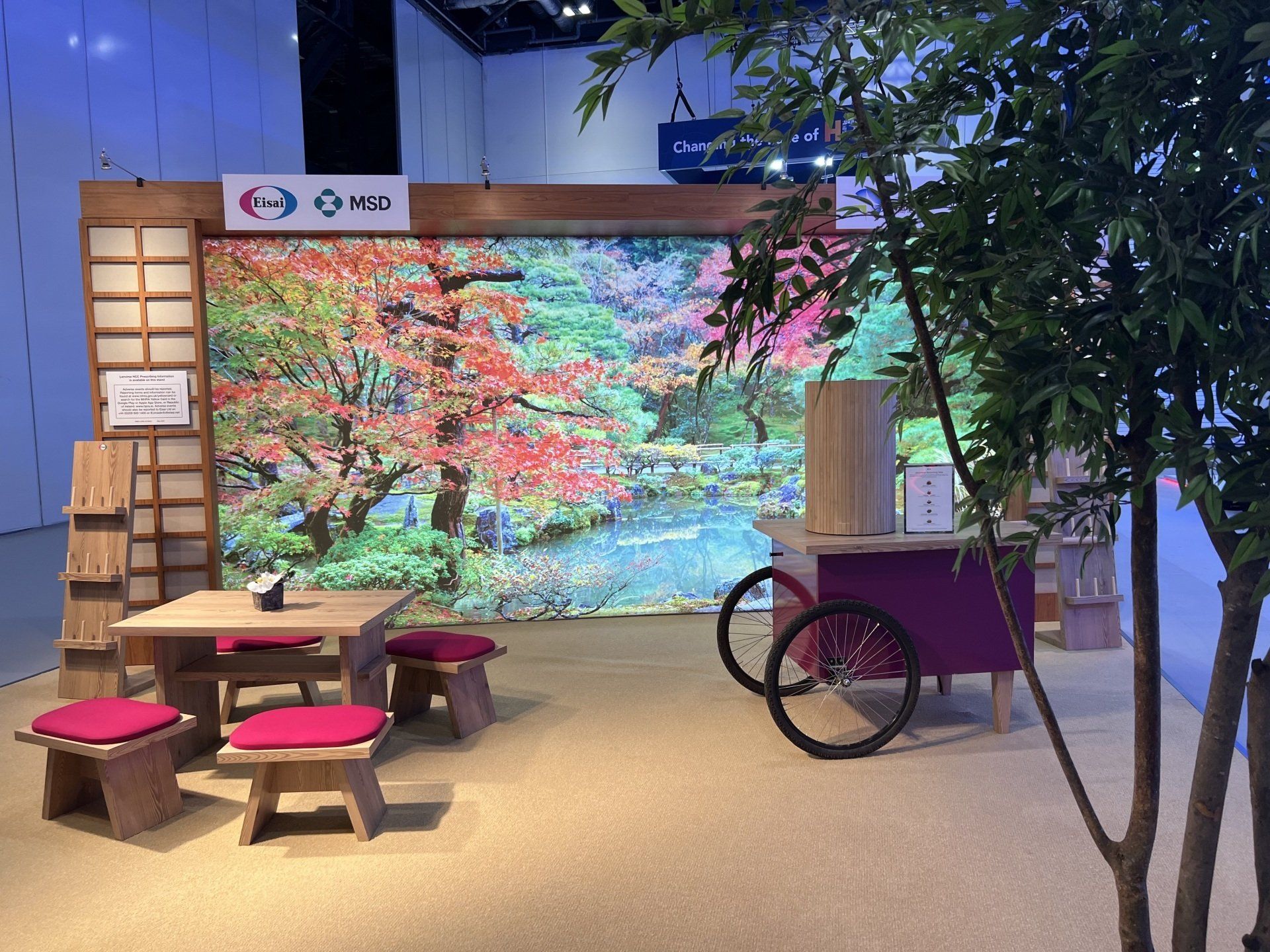 A room with a table and chairs in front of a wall with a picture of trees on it.