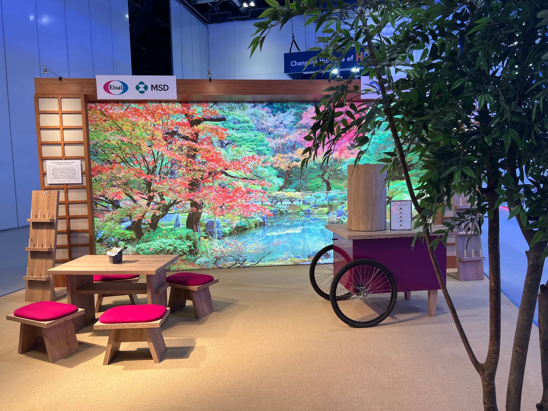 A room with a table and chairs in front of a large screen.