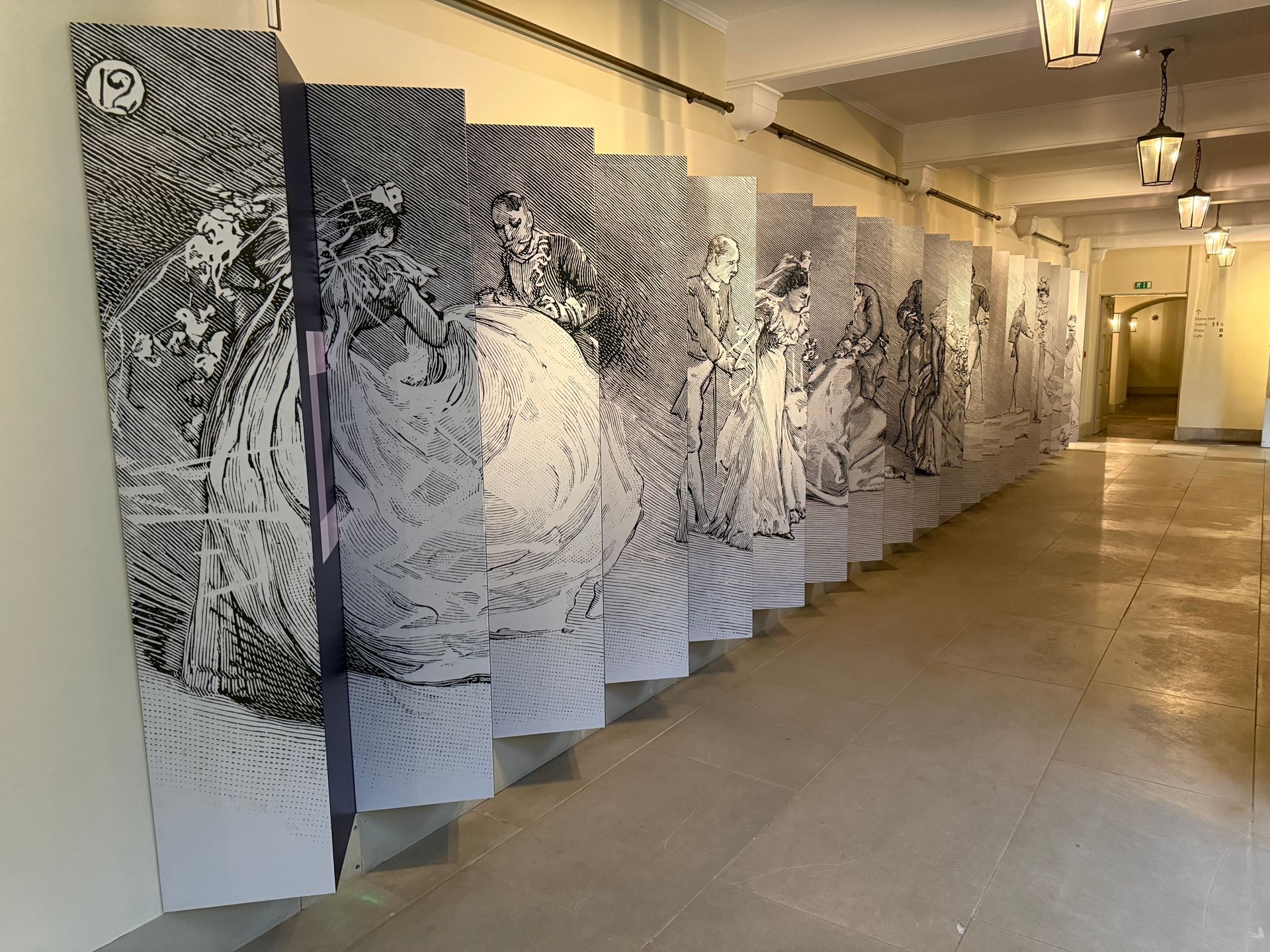 A long hallway with a lot of paintings on the wall.