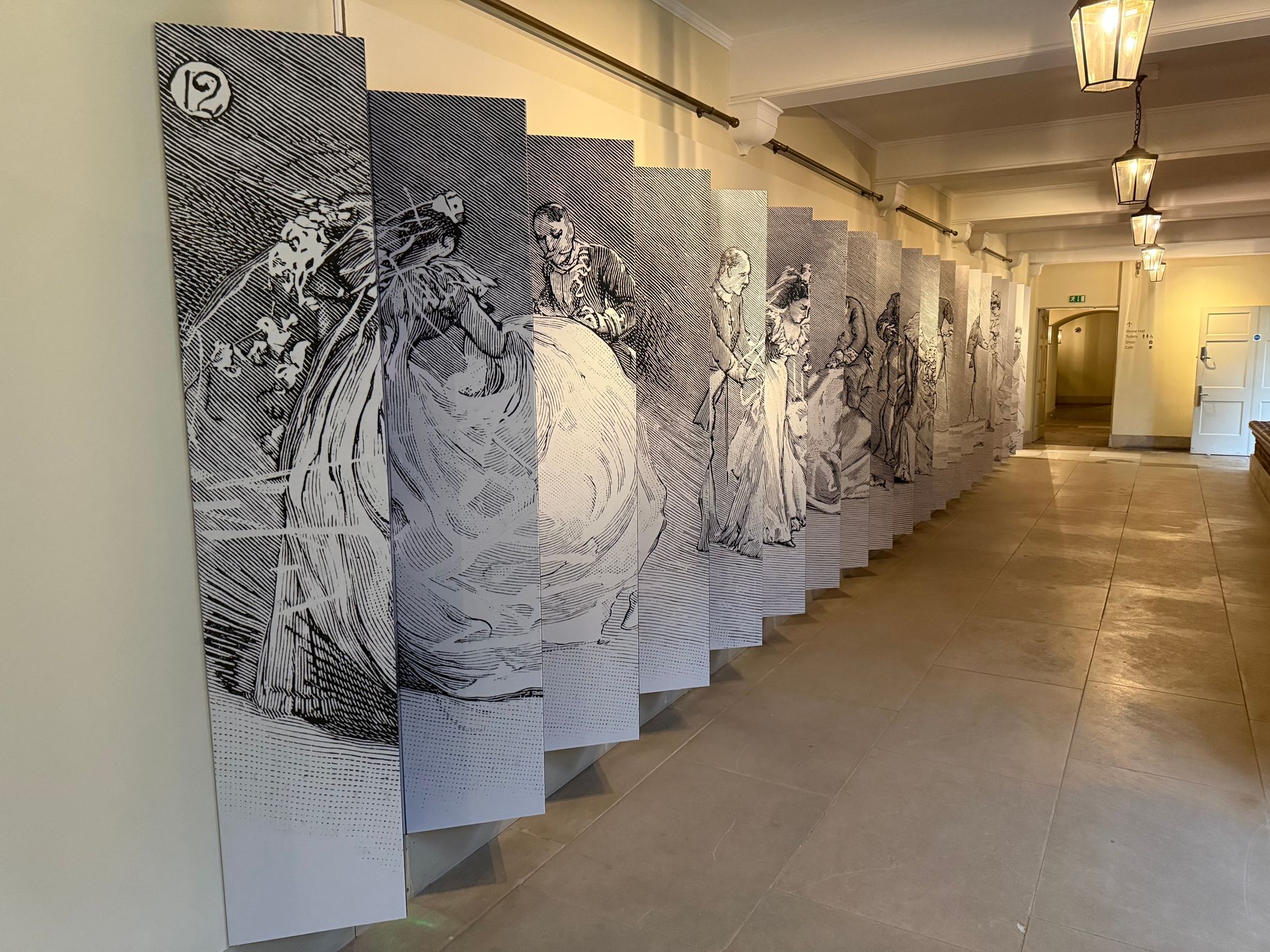A long hallway with a lot of paintings on the wall.