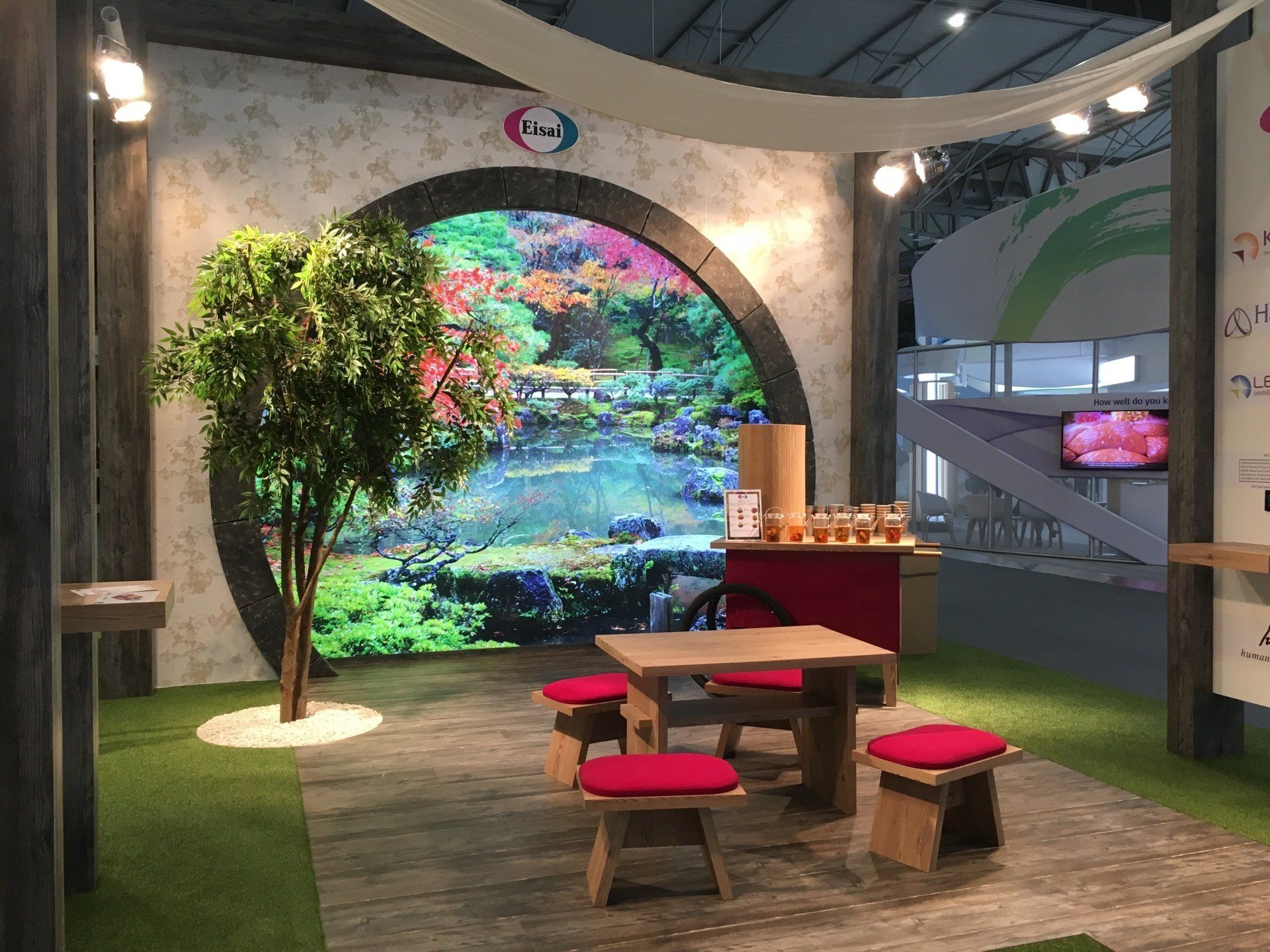 A room with a table and chairs in front of a large screen.