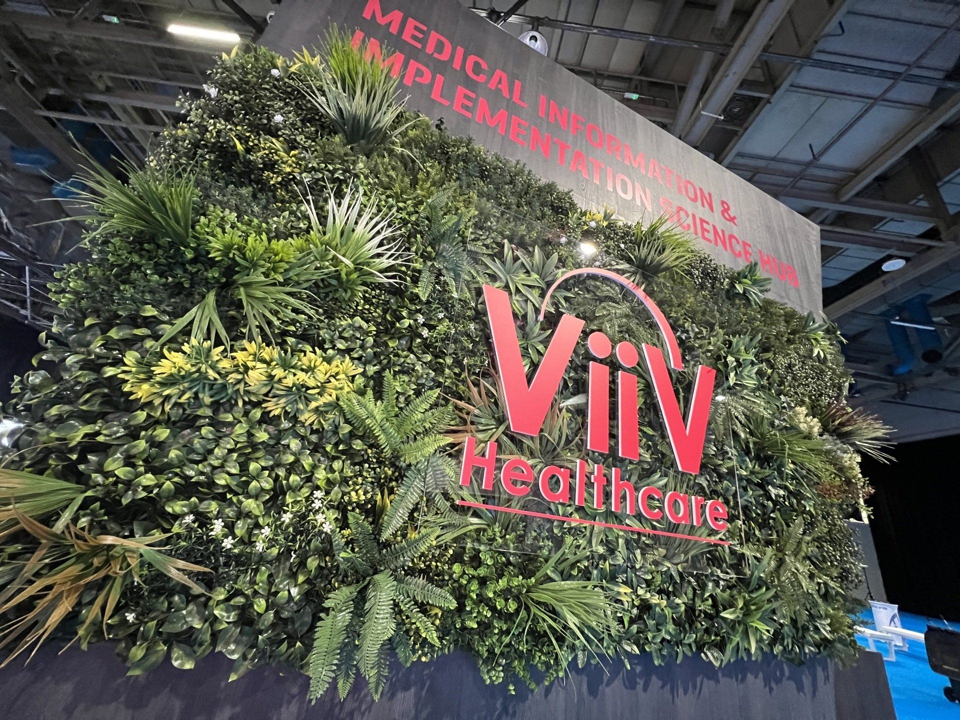 A sign for viiv healthcare is surrounded by plants