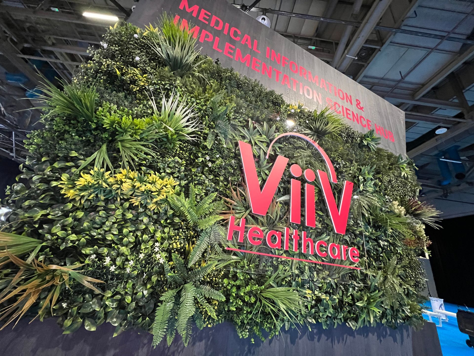 A wall with plants and a sign that says viv healthcare