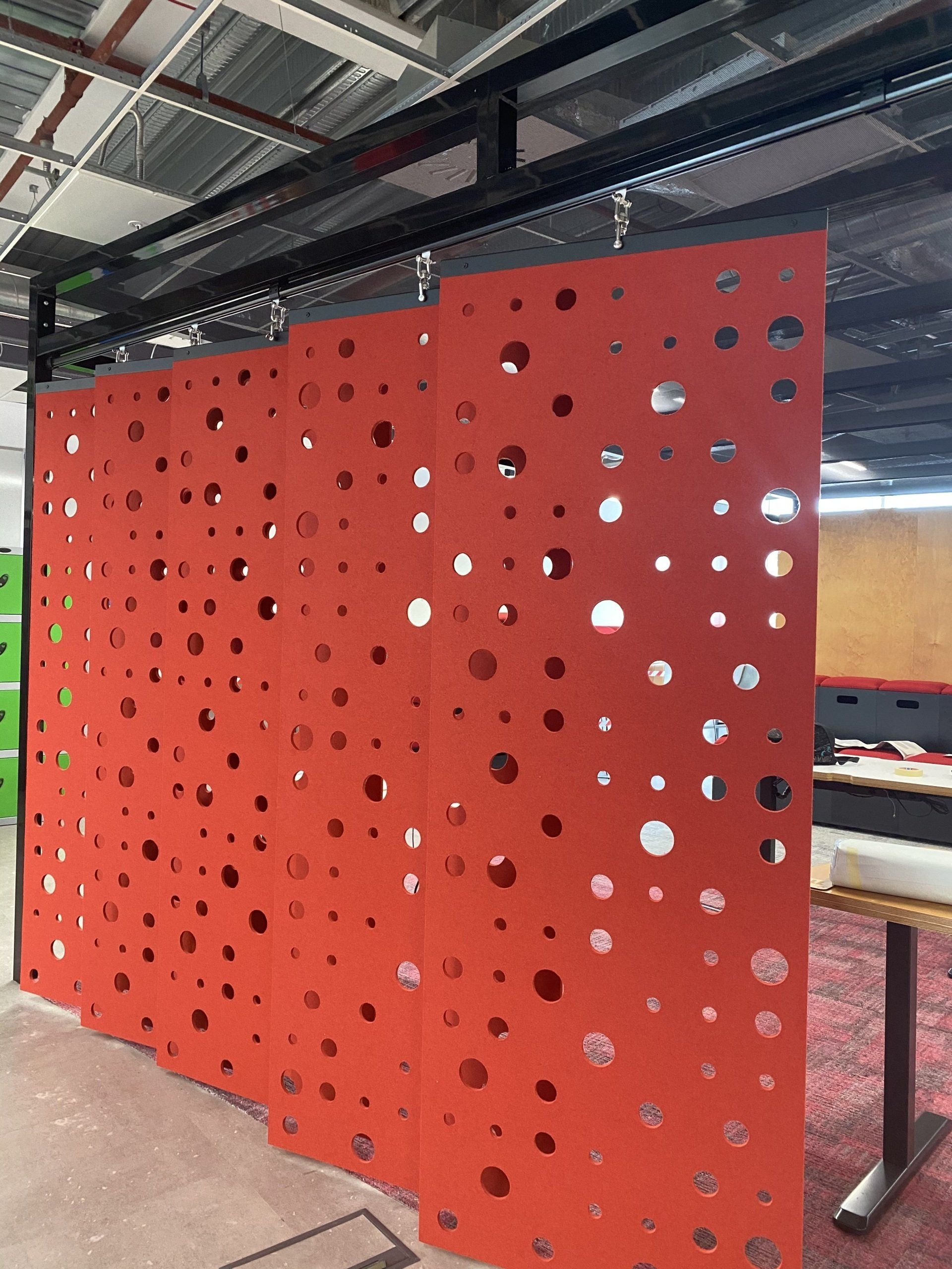 A red wall with holes in it and a table in the background.