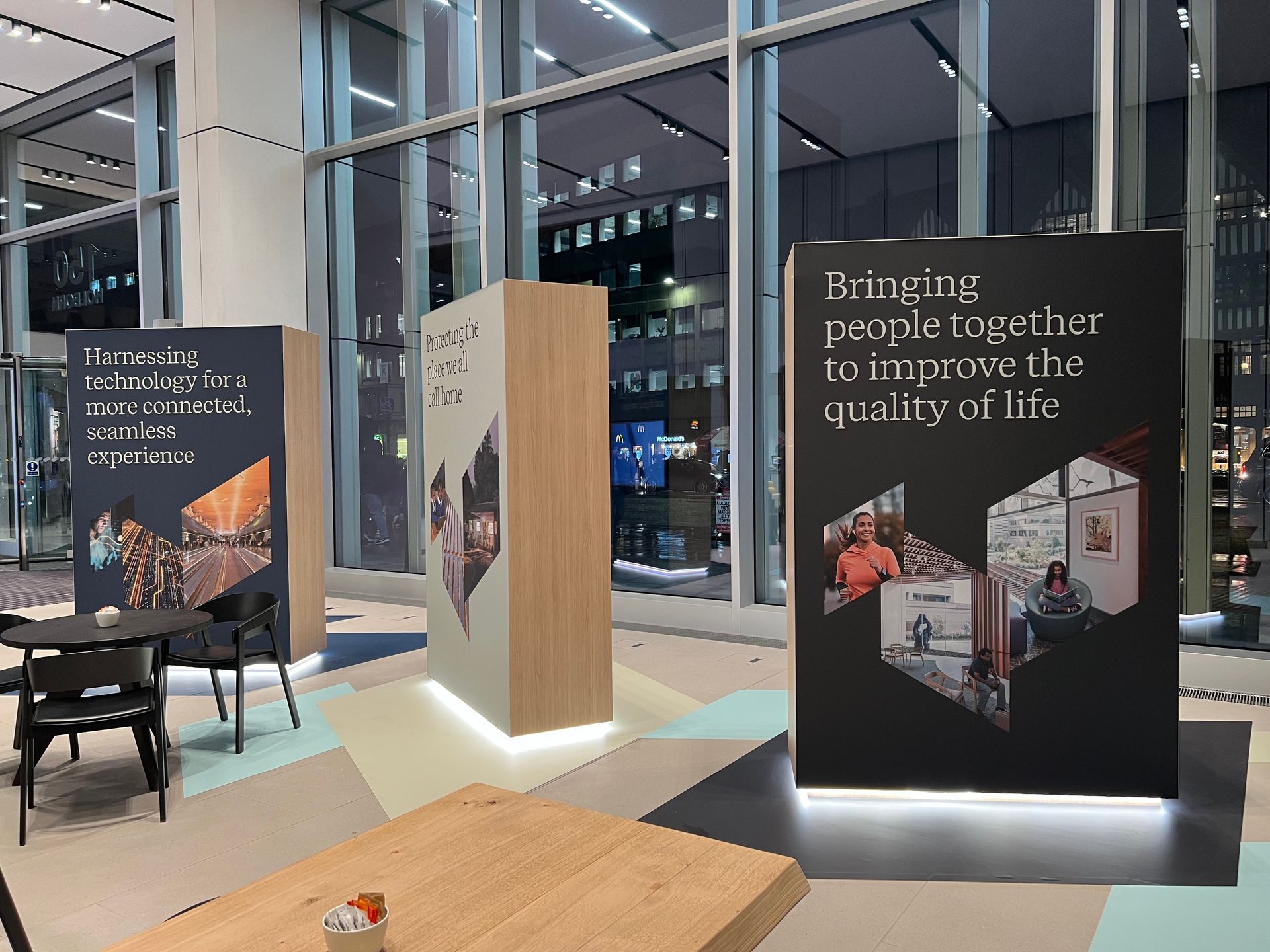 A room with a table and chairs and a sign that says `` bringing people together to improve the quality of life ''.