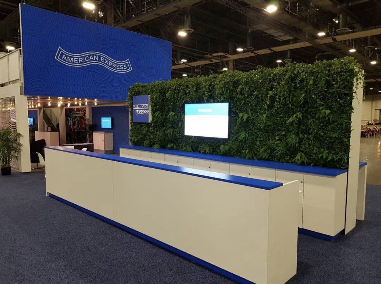 A blue and white booth with a green wall behind it.