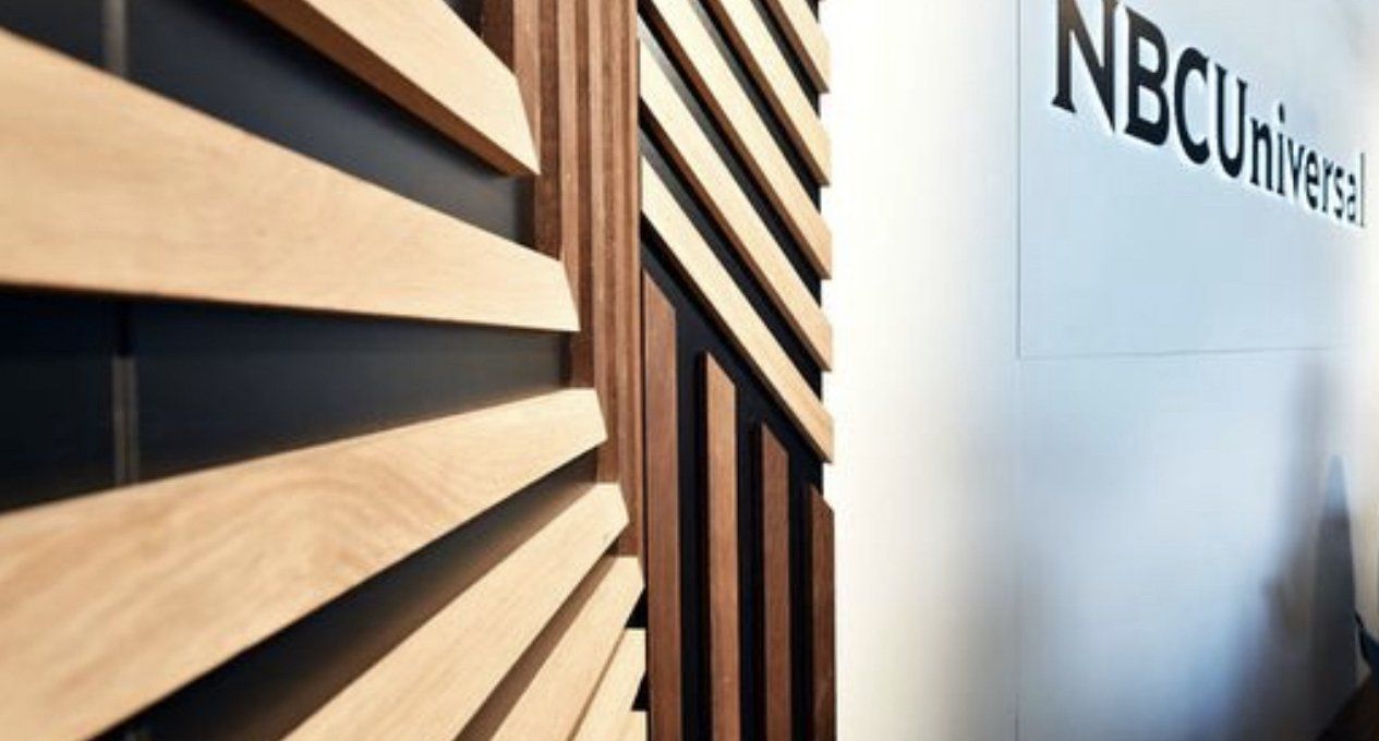 A wooden wall with a sign that says nbcuniversal on it.