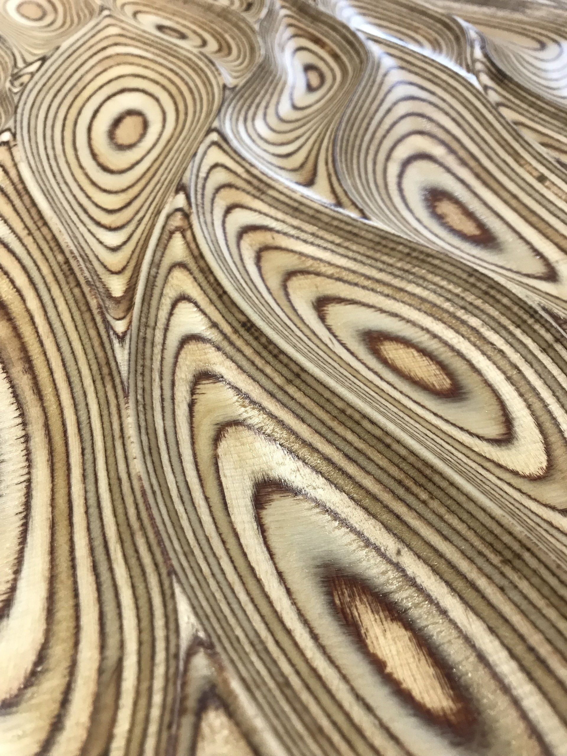 A close up of a piece of wood with a swirl pattern.