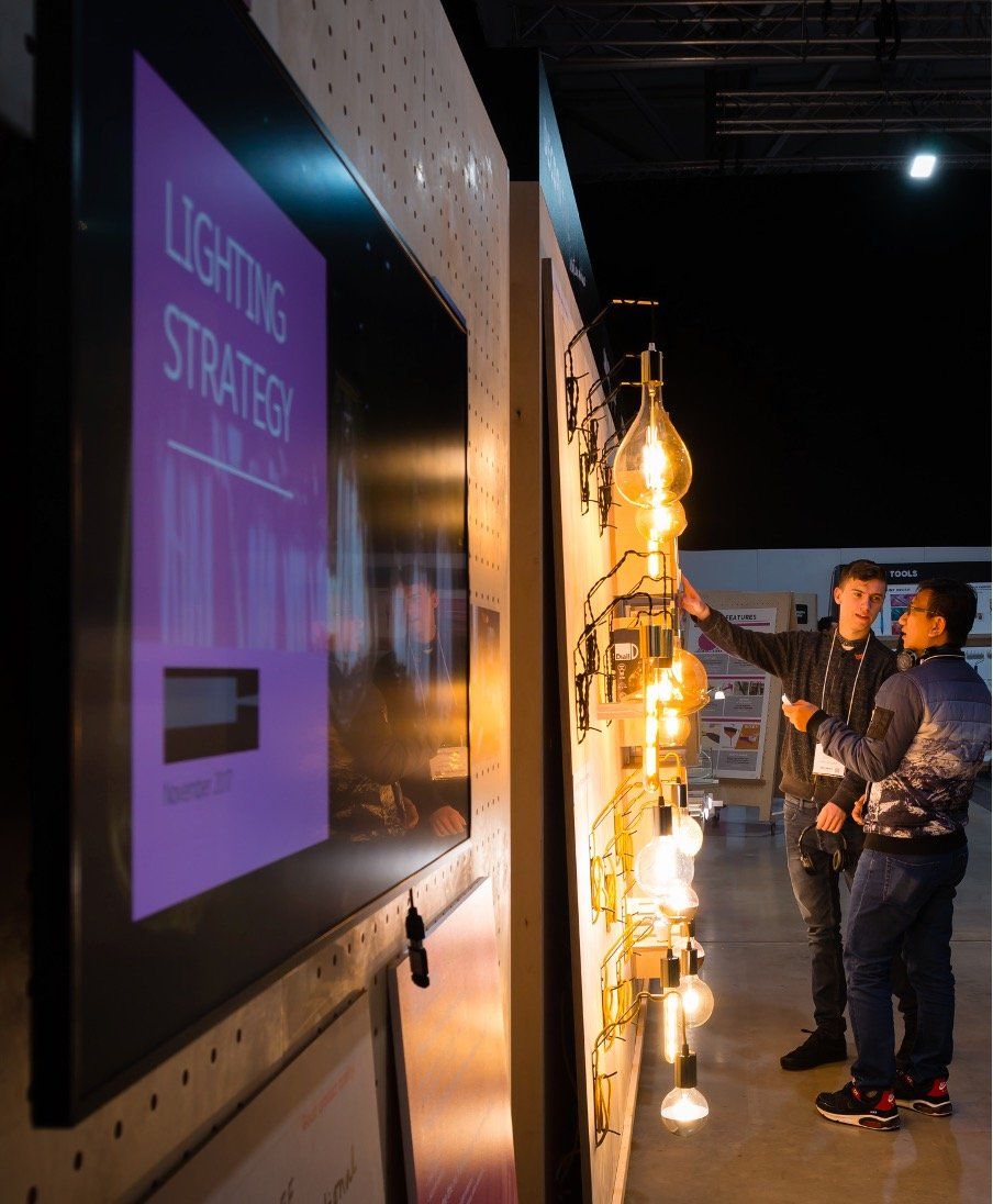 Two men are looking at a display of lighting strategies