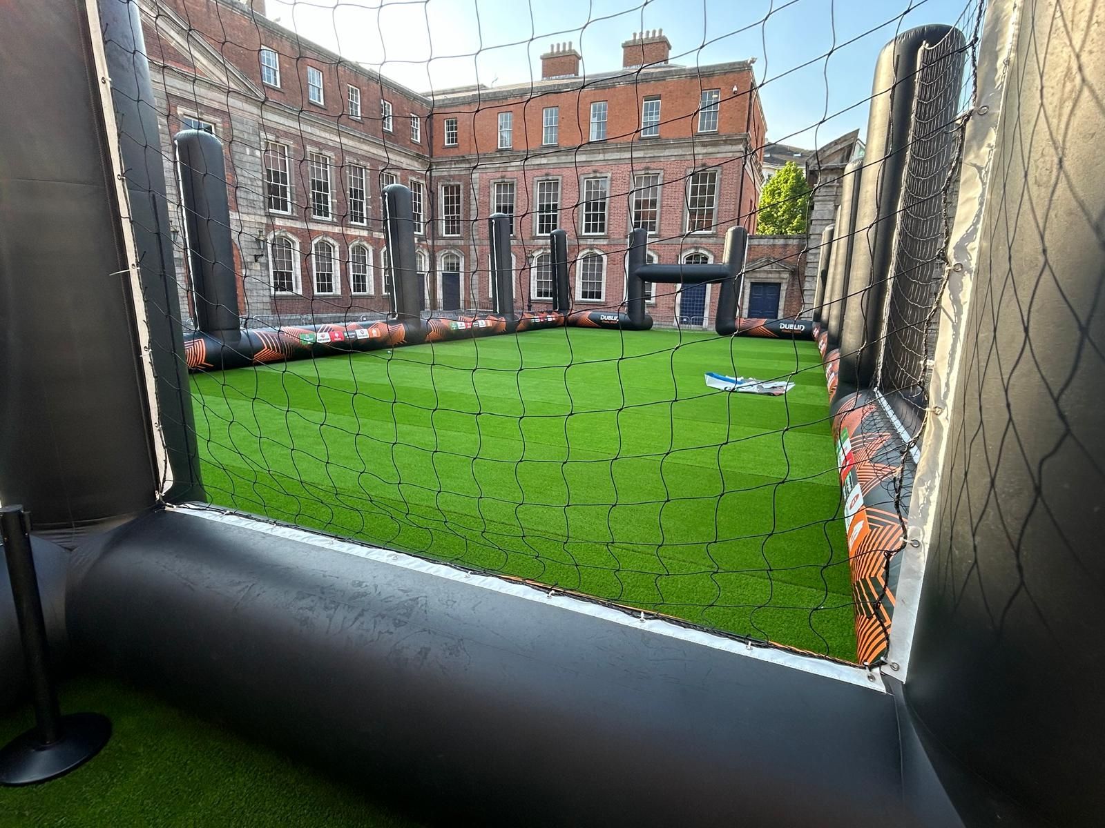 A view of a soccer field through a fence.