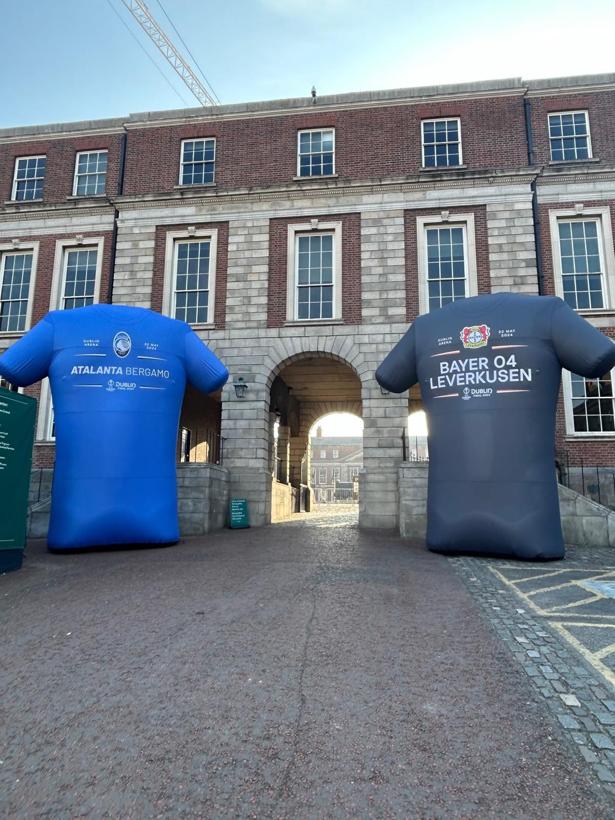 Two inflatable t-shirts are in front of a brick building