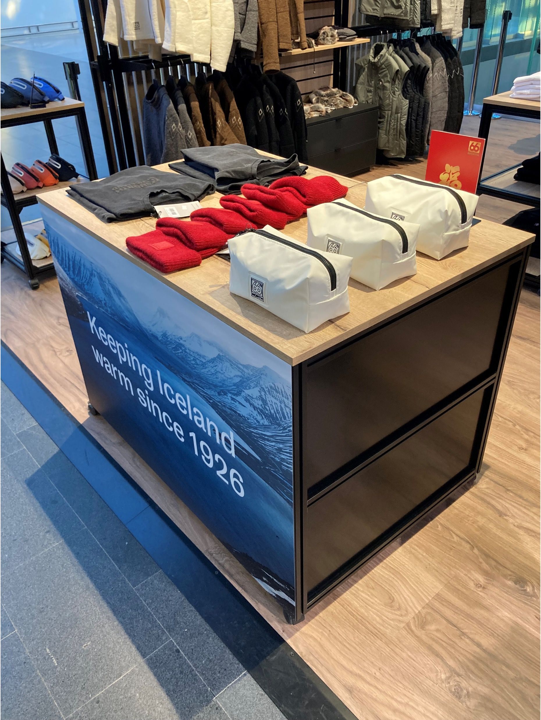 A table with clothes and bags on it in a store.