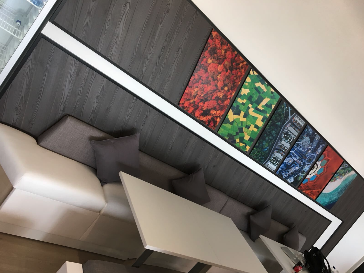 A living room with a couch and a table with pictures on the wall