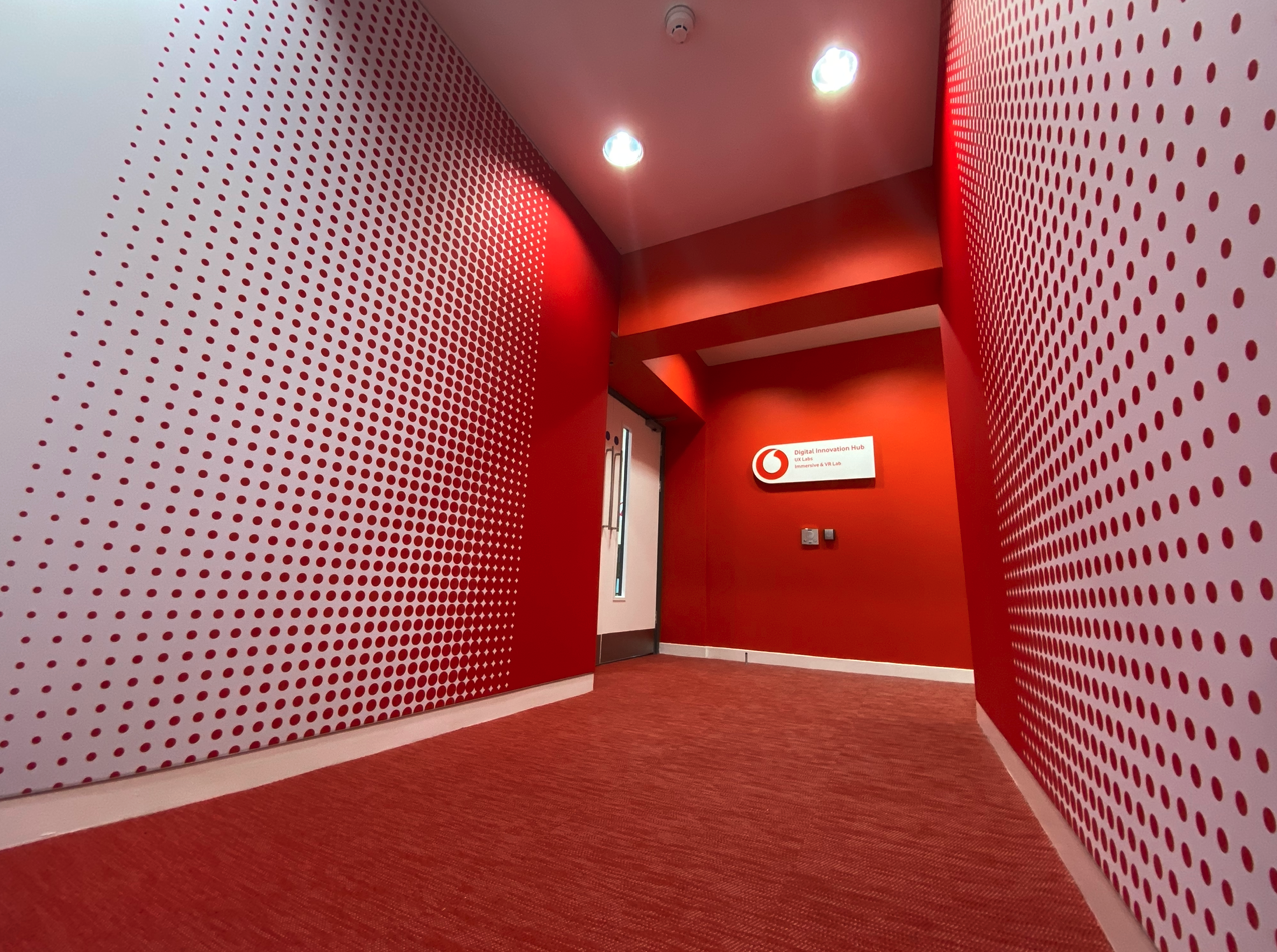 A hallway with red walls and a sign that says vodafone