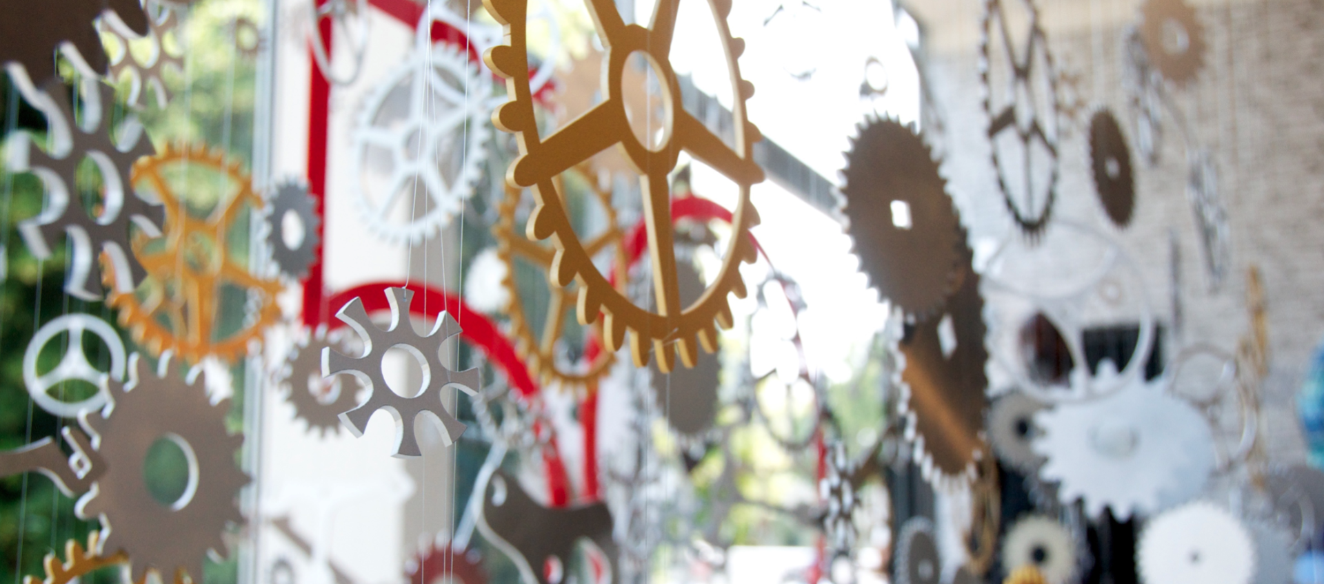 A bunch of gears are hanging on a window.