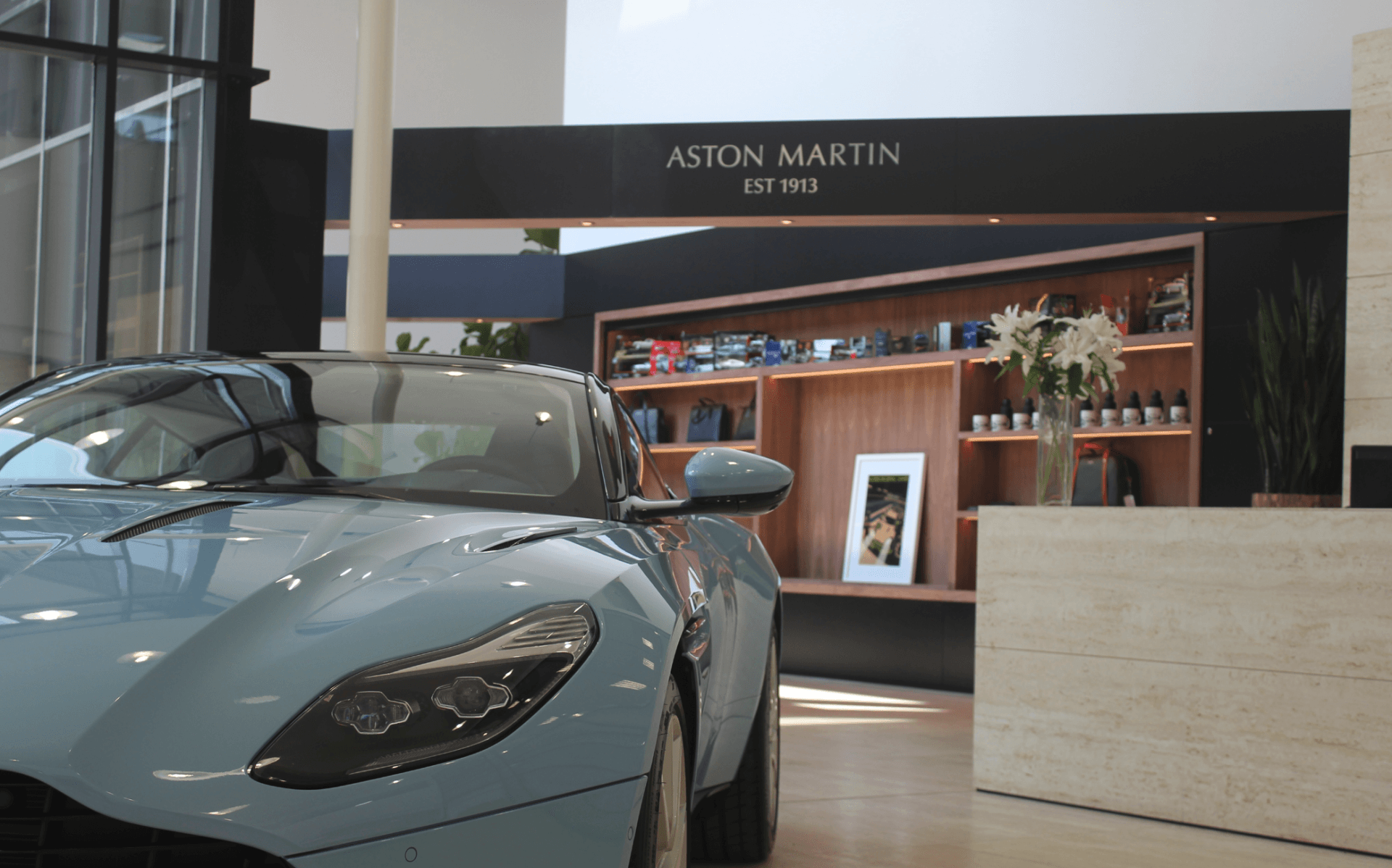 A car is parked in front of a sign that says aston martin