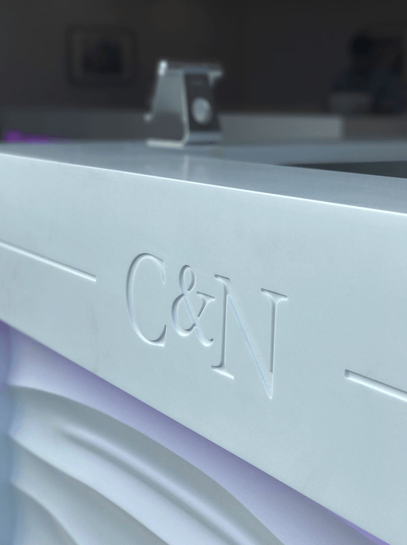 The letters c and n are carved into a white surface