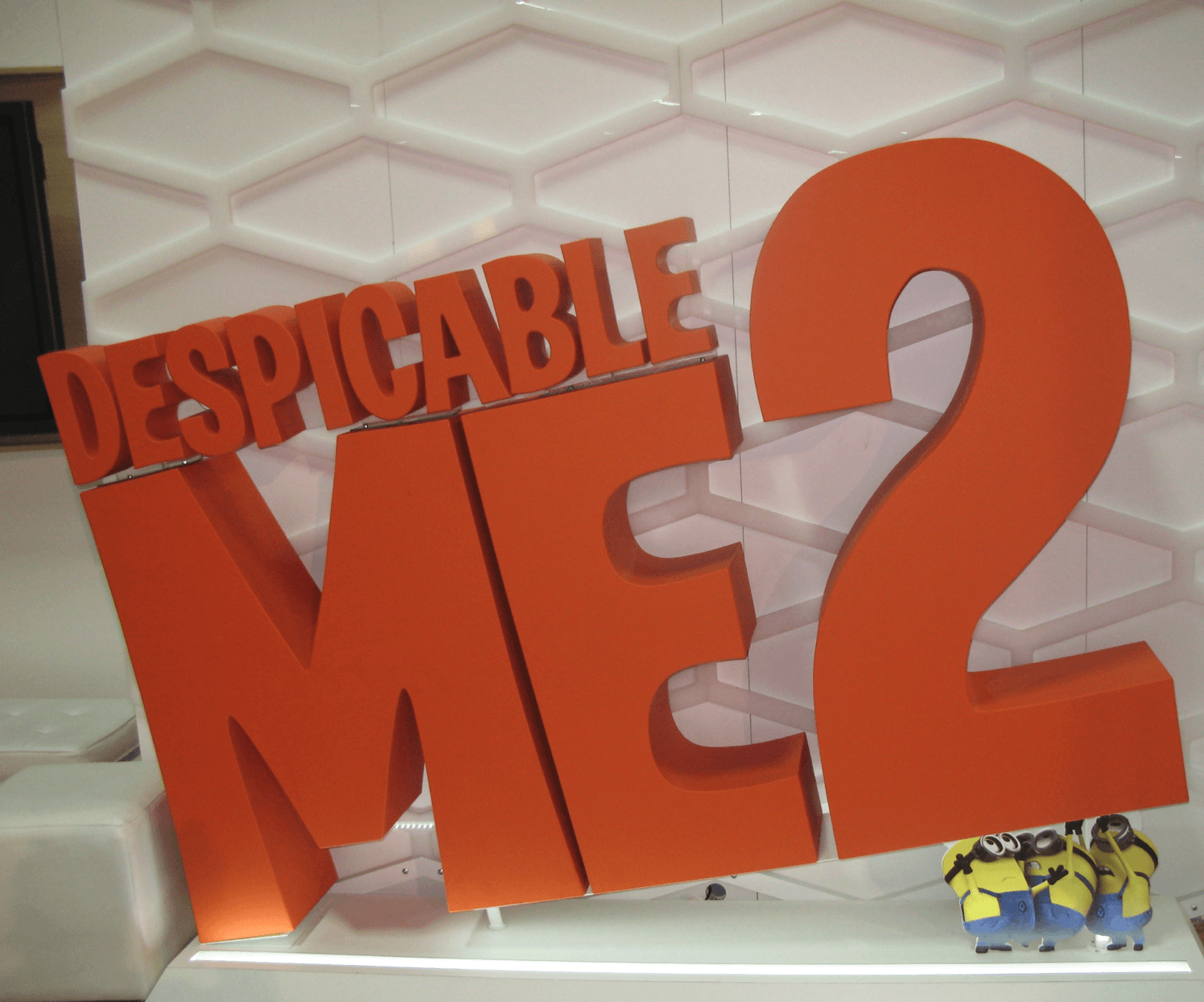 A despicable me 2 sign with minions in the background