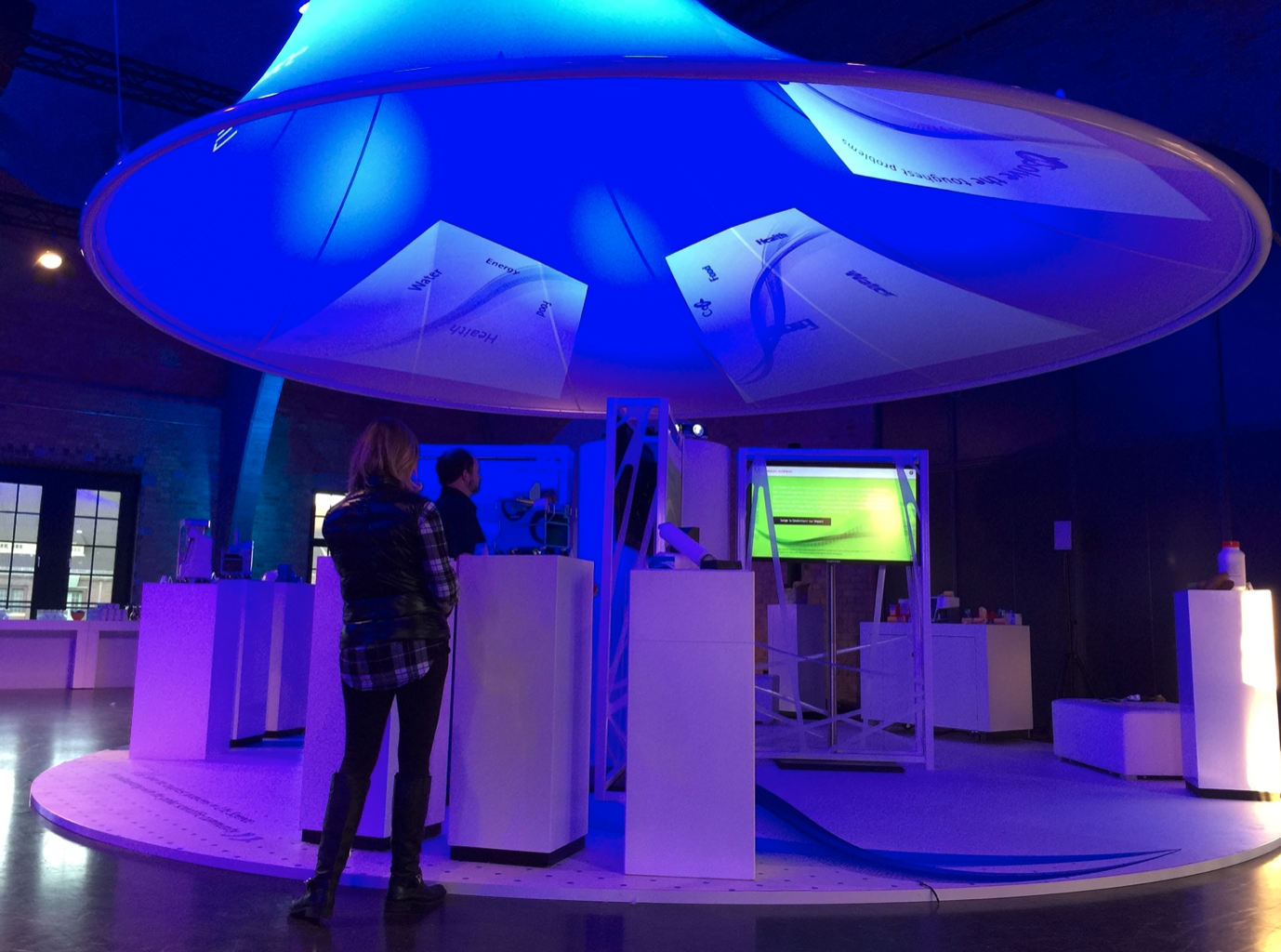 A woman stands in a room with a blue light on the ceiling