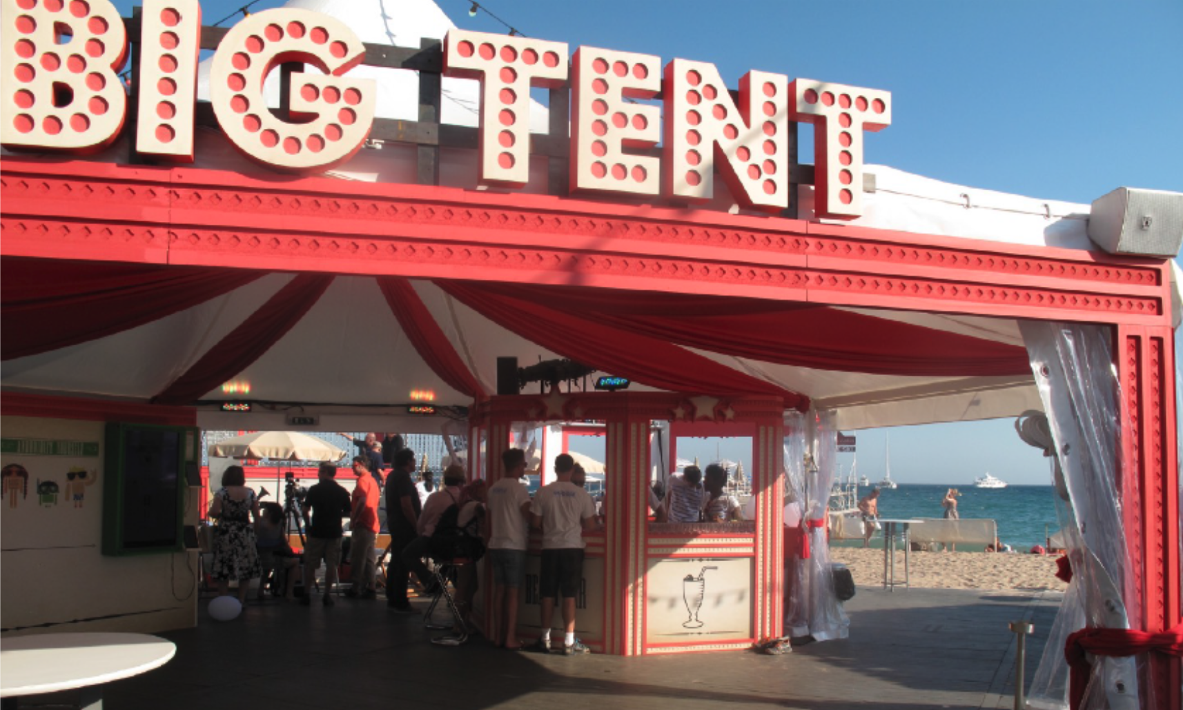 A group of people are standing in front of a big tent