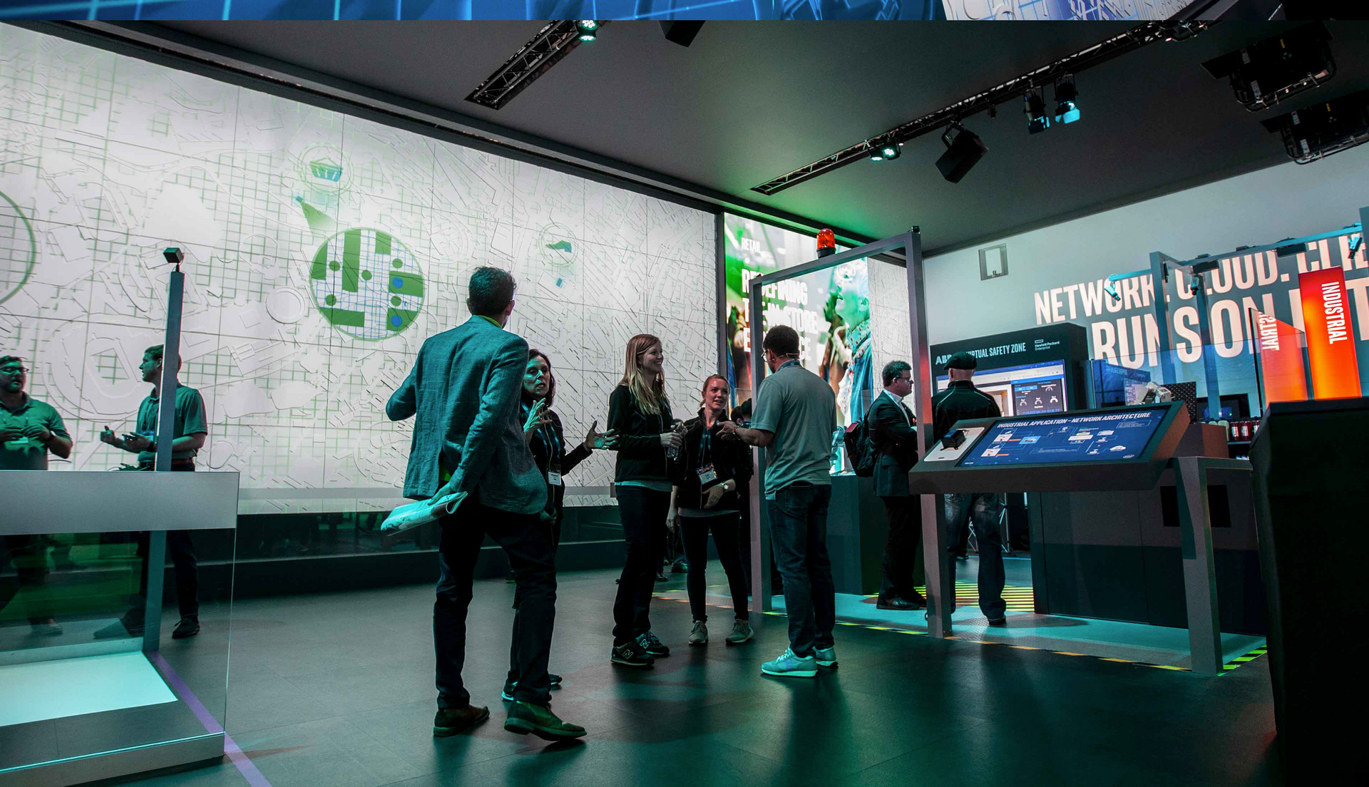 A group of people are standing in a room in front of a large screen.