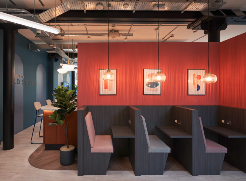 A room with a red wall and a row of booths.