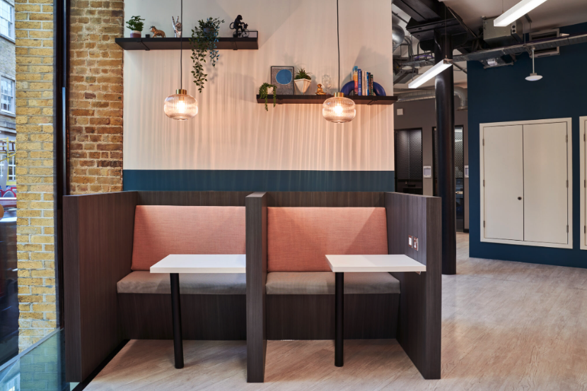 A room with a couch and two tables in it.