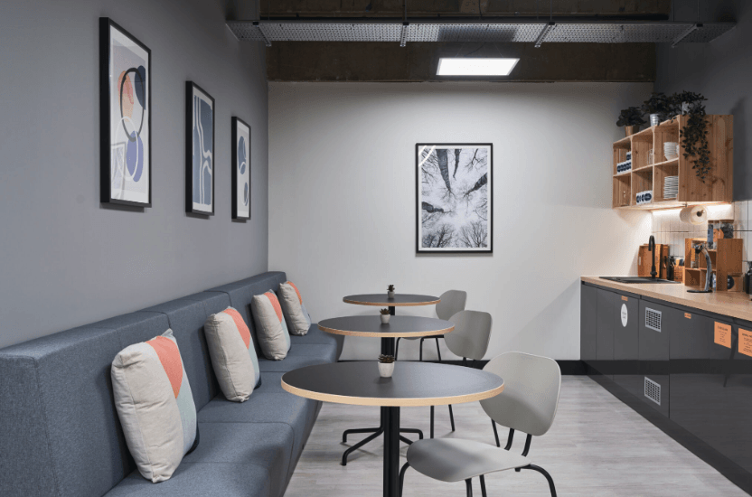 A kitchen with tables and chairs and a couch.