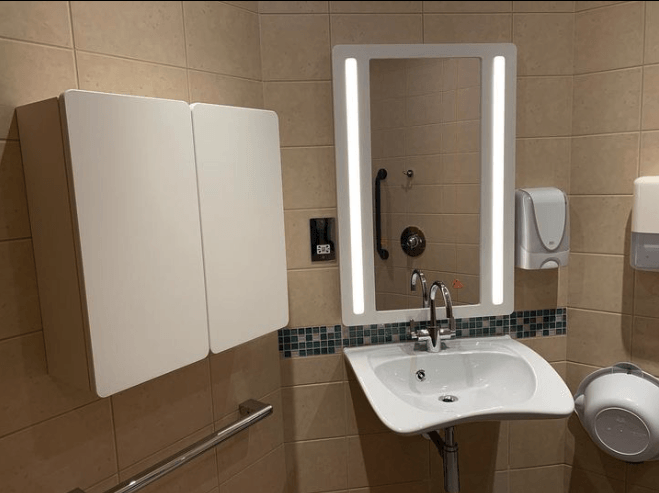 A bathroom with a sink a mirror and a cabinet