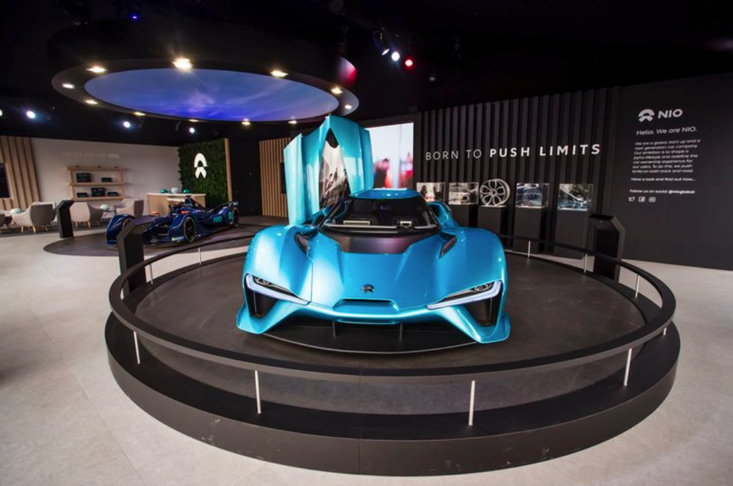 A blue sports car is on display in a room.