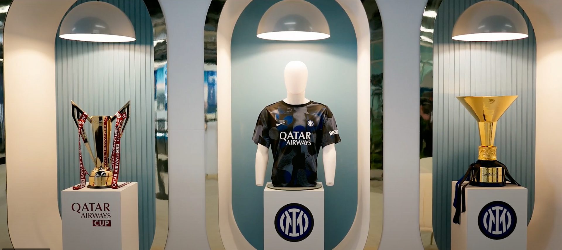 A mannequin is standing in front of three trophies.