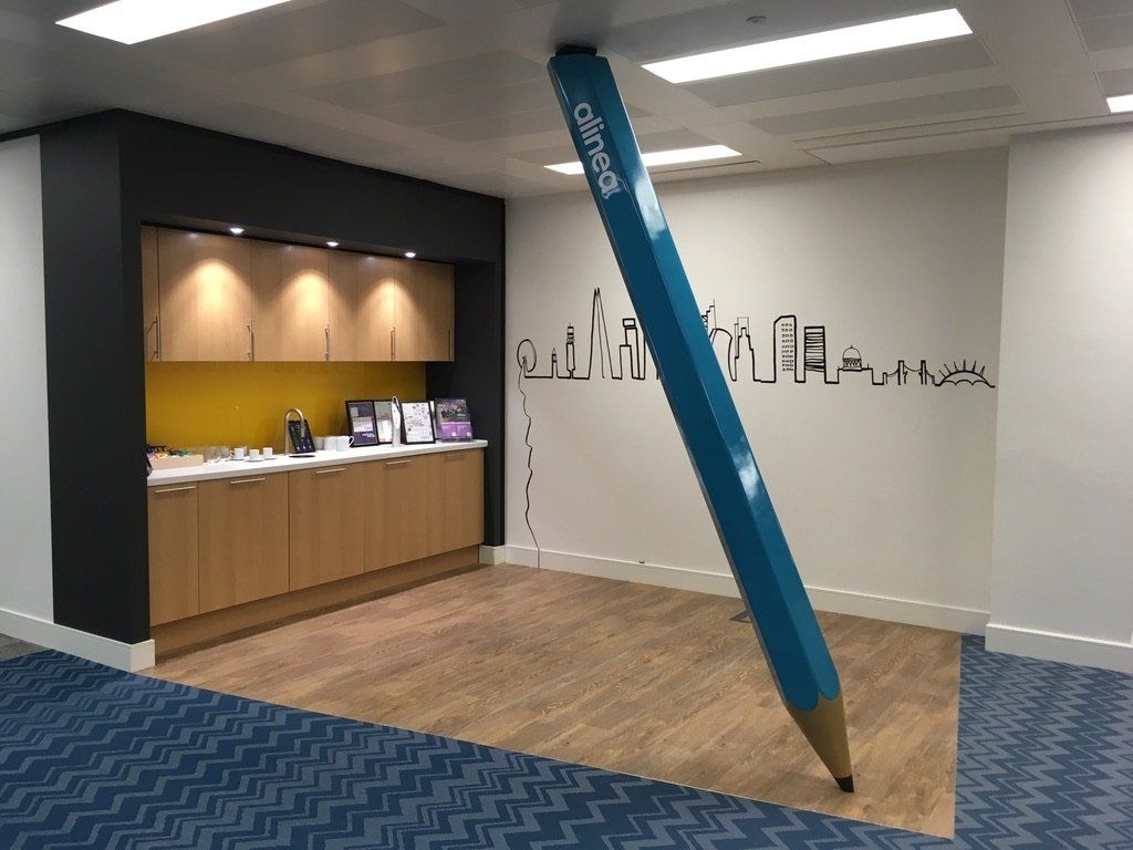 A large blue pencil is hanging from the ceiling in a room
