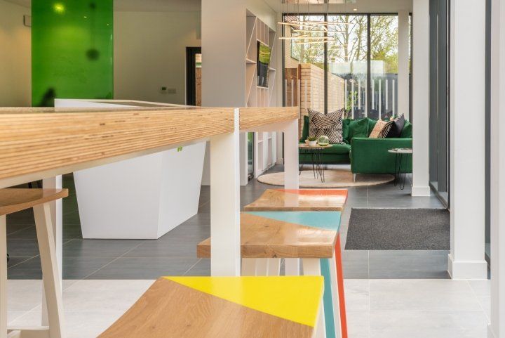 A living room with a green couch and a wooden table