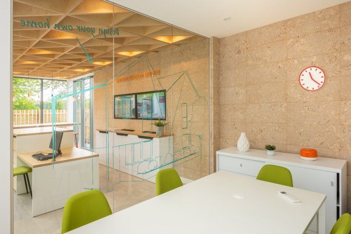 A conference room with a table and chairs and a clock on the wall.