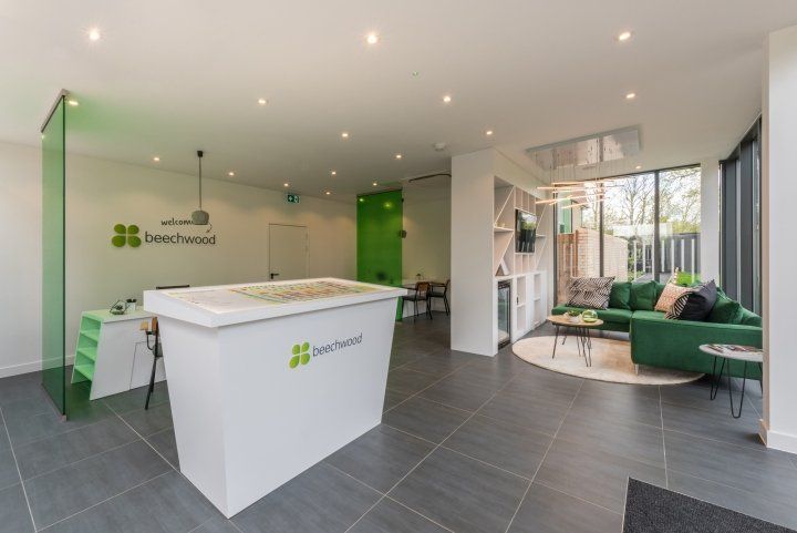 A living room with a green couch and a white counter.