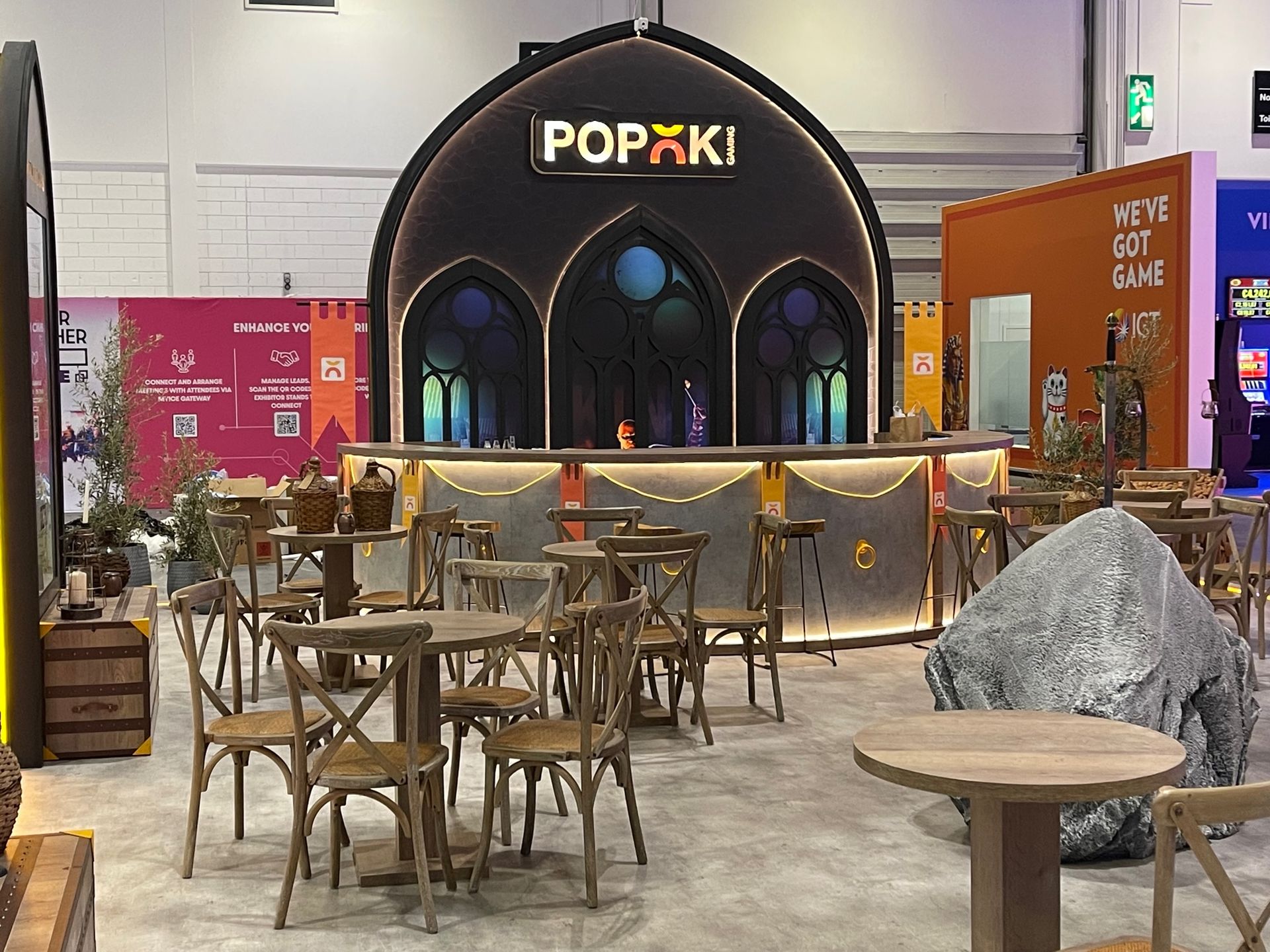A restaurant with tables and chairs and a sign that says popki
