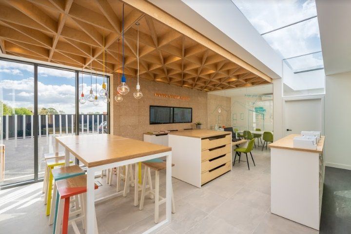 A room with a long table and stools in it.