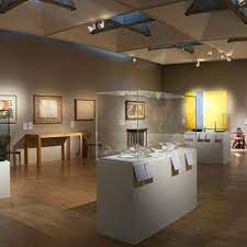 A museum filled with lots of exhibits and tables and chairs.