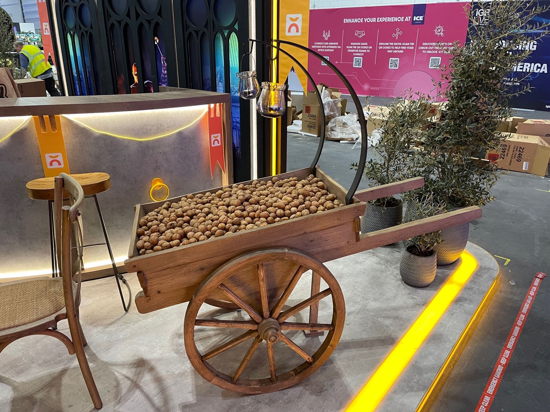 A wooden cart filled with nuts is on display in a room.