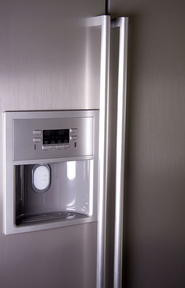 A stainless steel refrigerator with a water dispenser on the side.